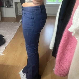 Mörkblå bootcut byxor Jenny Skavlan - Mörkblå bootcut byxor från Jenny Skavlan med hjärtformat bakficka. Snygg passform med normal midja och klassiska fickor fram. Super söta marinblåa, knappt använda, storlek 25