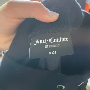 Marinblå Juicy Couture byxor❤️ - Mörkblåa byxor från Juicy Couture i storlek XXS. Byxorna har bootcut-modell! En av plumparna har fallit av men det syns inte när man bär dem på💕pris i butik är runt 800kr