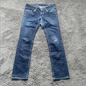 Blå jeans från G-Star RAW W31 L34 - Snygga blå jeans från G-Star RAW med klassisk femficksdesign och läderpatch bak. Jeansen har raka ben och normal passform, tillverkade i slitstarkt denim. Perfekta för dig som gillar en stilren och tidlös look. 
