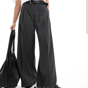 Mörkgrå vida kostymbyxor - Mörkgrå vida kostymbyxor. Helt nya med prislapp kvar. Säljer pga att tiden för att returnera gått ut (därav säljer jag dessa i två storlekar). Nypris 419 kr! 