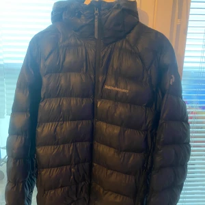 Svart dunjacka Peak Performance - Säljer en svart dunjacka från Peak Performance strl M . Använd under förra vintern men i mycket fint skick. Har tyvärr växt ur den, därför säljes. Mitt pris: 1500 kr. Finns att hämta på plats.