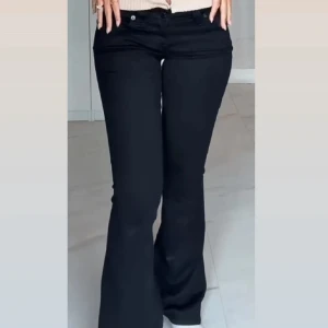 True Religion Jeans - Snygga svarta byxor med bootcut passform och låg midja. Byxorna har stora fickor bak med knappdetalj och klassisk jeanslook. Använda men i bra skick.