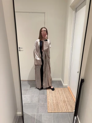 Open Abaya - Säljer min open abaya, den är skimrig i champagne färg. Jag är 166 cm lång. Använd en gång förra året, men inga defekter. 🤍