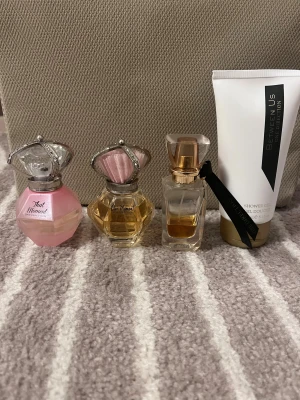 One Direction parfymset - Säljer tre parfymer och en duschgel från One Direction. Parfymerna är 'That Moment' i rosa flaska med silverdetaljer, 'Our Moment' i transparent flaska med rosa och silverkrona, samt 'Between Us' i rektangulär flaska med guldlock och svart band. Duschgelen är vit med guldfärgad kork.