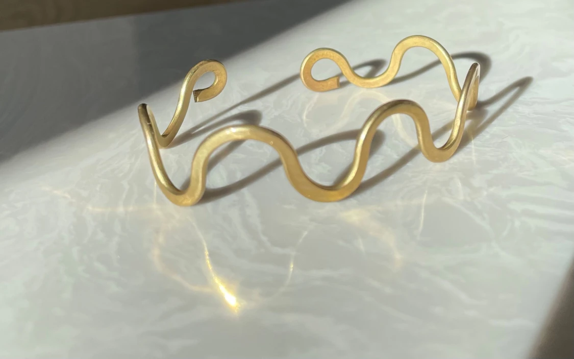 Vågigt guldarmband i aluminium 