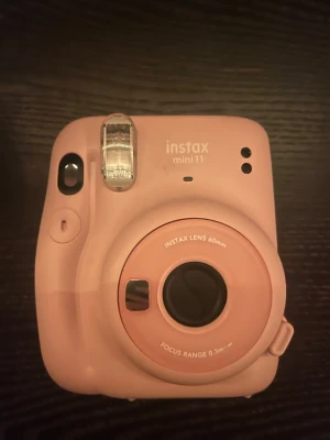 Instax Mini 11 - Snygg rosa Instax Mini 11 direktbildskamera från Fujifilm. Kameran är i fint skick med inga synliga repor eller skador. Perfekt för att ta roliga och spontana bilder med vänner. Enkel att använda och passar både nybörjare och fotoentusiaster.