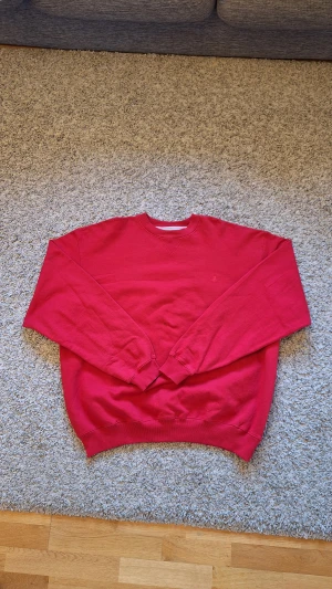 Röd Champion sweatshirt  - Snygg röd Champion sweatshirt i storlek XXL, men skulle nog säga den sitter mer som XL/L. Regular Fit. Använda fåtal gånger och skicket är jättebra, inga defekter eller slitningar finns. Skick: 8/10