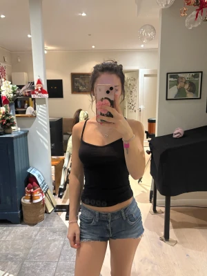 Blå jeansshorts med rå kant - Säljer ett par blå denimshorts med låg midja och rå, fransig kant.