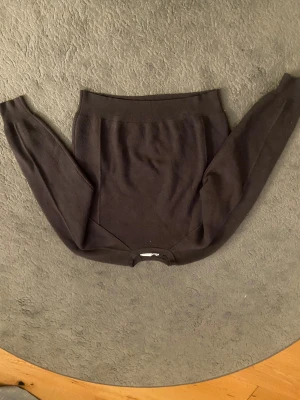 Mörkbrun stickad tröja från Zara - Snygg mörkbrun stickad tröja från Zara i storlek S. Tröjan har en klassisk rund hals och långa ärmar, perfekt för dig som gillar enkel och stilren design. Materialet är mjukt och skönt, vilket gör den riktigt bekväm att bära.