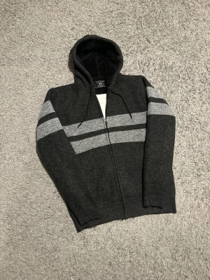 Fodrad och stickad hoodie med zip - Säljer en UNIK stickad svart hoodie med zip. Tröjan är i nyskick 9/10. Inga defekter!! Den har en klassiskt tyg med zip öppning. 😮‍💨 Tveka inte på att höra av dig!💪🏼