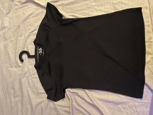 Svart t-shirt från lager 157 - Snygg svart t-shirt från 15% i storlek Small. Modellen är klassisk med rund hals och korta ärmar, perfekt för dig som gillar enkel och stilren design. Materialet känns lätt och smidigt, vilket gör den skön att ha på sig hela dagen.