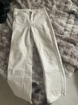 Midwaist vita raka jeans - Snygga vita midwaist jeans med raka ben. Jag är 160 och de är lite korta på mig. Klassisk femficksmodell med knapp och dragkedja framtill. Perfekta för dig som gillar en clean och fräsch look. Passar till allt och är superenkla att styla.