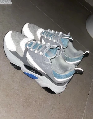 dior b22 - säljer 2 månaders använda dior b22. skick:7/10. skorna är i bra kvalitet, bara lite mörk färgat vid de vita/ blåa delarna. skickas inom kort tid