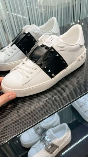 Valentino Rockstud sneakers vit/svart - STORLEK 39-39,5 Säljer ett par Valentino Rockstud Untitled sneakers i vitt skinn med svart band och ikoniska pyramidnitar. Skorna har rund tå, snörning och platt sula. Märket syns på både plös och sula. Perfekt för dig som gillar edgy designerstil. 
