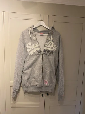 Grå hoodie från Superdry  - Säljer denna riktigt snygga vintage grå zip Hildur från superdry, perfekt att ha både hemma men även till skolan, storlek xl men sitter som en large, skriv vid frågor eller funderingar😍