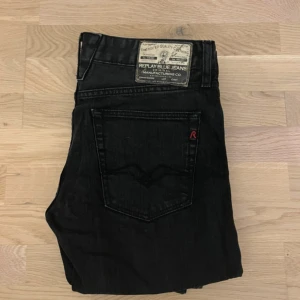 Svarta jeans från Replay - Snygga svarta jeans från Replay med klassisk femficksmodell och raka ben. Jeansen har en diskret logga på bakfickan och patch med Replay Blue Jeans på linningen. Perfekta till en avslappnad streetstil.