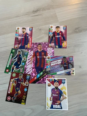 Samling FC Barcelona fotbollskort - Säljer en samling fotbollskort med spelare från FC Barcelona. Limited edition. Korten har olika färger och motiv, med spelare i klubbens klassiska blå-röda matchställ. Bland spelarna finns bland annat Gerard Piqué, Ansu Fati och Vidal. Perfekt för dig som samlar på fotbollskort eller älskar Barca!