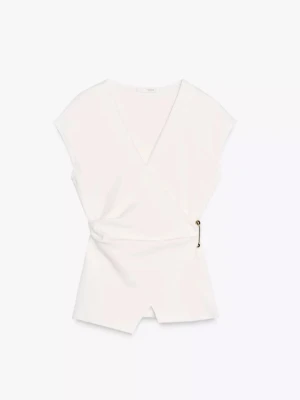 Vit omlottopp med v-ringning - Stilren vit omlottopp med v-ringning och korta ärmar. Toppen har en snygg detalj med knäppning i sidan och en lätt figurnära passform. Perfekt att matcha med jeans eller kjol för en trendig look.