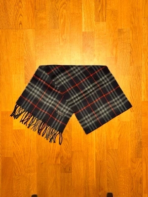 Mörkblå Burberry halsduk - Säljer en mörkblå halsduk från Burberry. Halsduken är i gott skick och är gjord i 100% lamull. Var inte rädd för några frågor. Pris diskuteras inte!