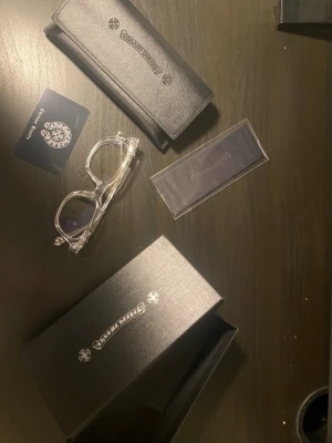 Chrome hearts glasögon (blue light) - Säljer genomskinliga glasögon från Chrome Hearts i stilren design med logga och detaljer i silverfärg. Fodralet är gjort i konstläder och kommer med putsduk och originalbox.