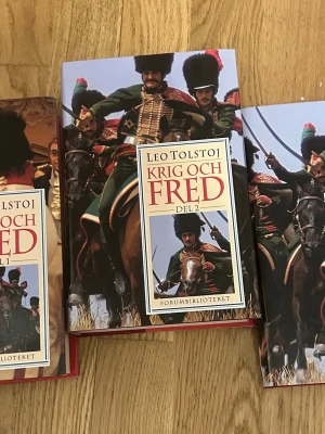 Krig och Fred av Leo Tolstoj, 3 delar - Säljer hela trilogin 'Krig och Fred' av Leo Tolstoj från Forumbiblioteket. Böckerna har hårda omslag med färgstarka illustrationer av kavallerister och röda baksidor. Perfekt för dig som gillar klassisk rysk litteratur och episka romaner.