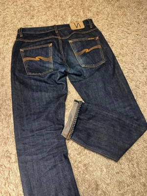 Dry Selvedge nudie jeans slim passform modell grim tim  - Dry Selvedge nudie jeans i slim passform modell grim tim med potentialen till en riktigt najs fade och påväg dit. Mycket bra skick inga märkvärdiga defekter. Storlek 32/32. Postas antigen samma dag som köp eller dagen därpå🙌💯