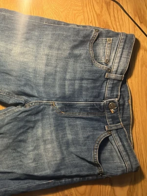 Blå jeans från Dondup Kids - Snygga blå jeans från Dondup Kids i klassisk denim med fem fickor och ljusa tvättade detaljer. Jeansen har normal midja och raka ben. Perfekta för en avslappnad och trendig look.