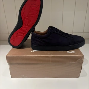 Mörkblå sneakers från Christian Louboutin - Snygga mörkblå sneakers från Christian Louboutin med klassisk röd sula och diskret logga på hälen. Storlek 39. 