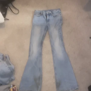 Bootcut ljusblå jeans från weekday  - Säljer ett par ljusblå jeans från weekday med klassisk bootcut-passform. Jeansen har en snygg tvätt med slitningar framtill. Osäker på storlek därför billigare. 32 eller 34