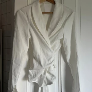 Vit omlott skjorta med knyt - Snygg vit omlott skjorta med bred krage och knyt i midjan.  Storlek S