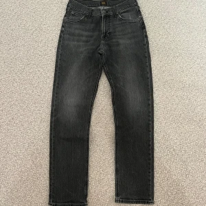 Svarta jeans från Lee W30 L32 - Svarta/gråa jeans från Lee i modellen WEST med raka ben/normal passform. Storl W30 L32. De har inga tecken av användning. NYPRIS: 1099