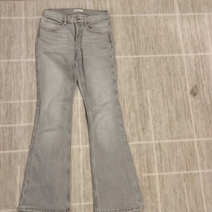 Grå bootcut jeans från Gina Tricot - Gråa Mid Waist Bootcut jeans från Gina Tricot. Tillverkat i ett mjukt och bekvämt denimtyg. Bara använd några gånger så har ett mycket bra skick.