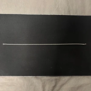  silverfärgad kordell halsband  - Säljer en stilren och tunn halskedja i silverfärg med diskret tvinnad design. Perfekt att bära som den är eller kombinera med ett hängsmycke. Kedjan har ett litet lås och passar dig som gillar minimalistiska smycken.