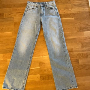  Nya Ljusblå raka jeans strl 36 - Säljer ett par ljusblå jeans i rak modell med normal midja och full längd. Klassisk femficksdesign och knappstängning fram. Jeansen är tillverkade i bomull och har en clean look utan slitningar eller mönster. Perfekta för en chill och stilren vibe.