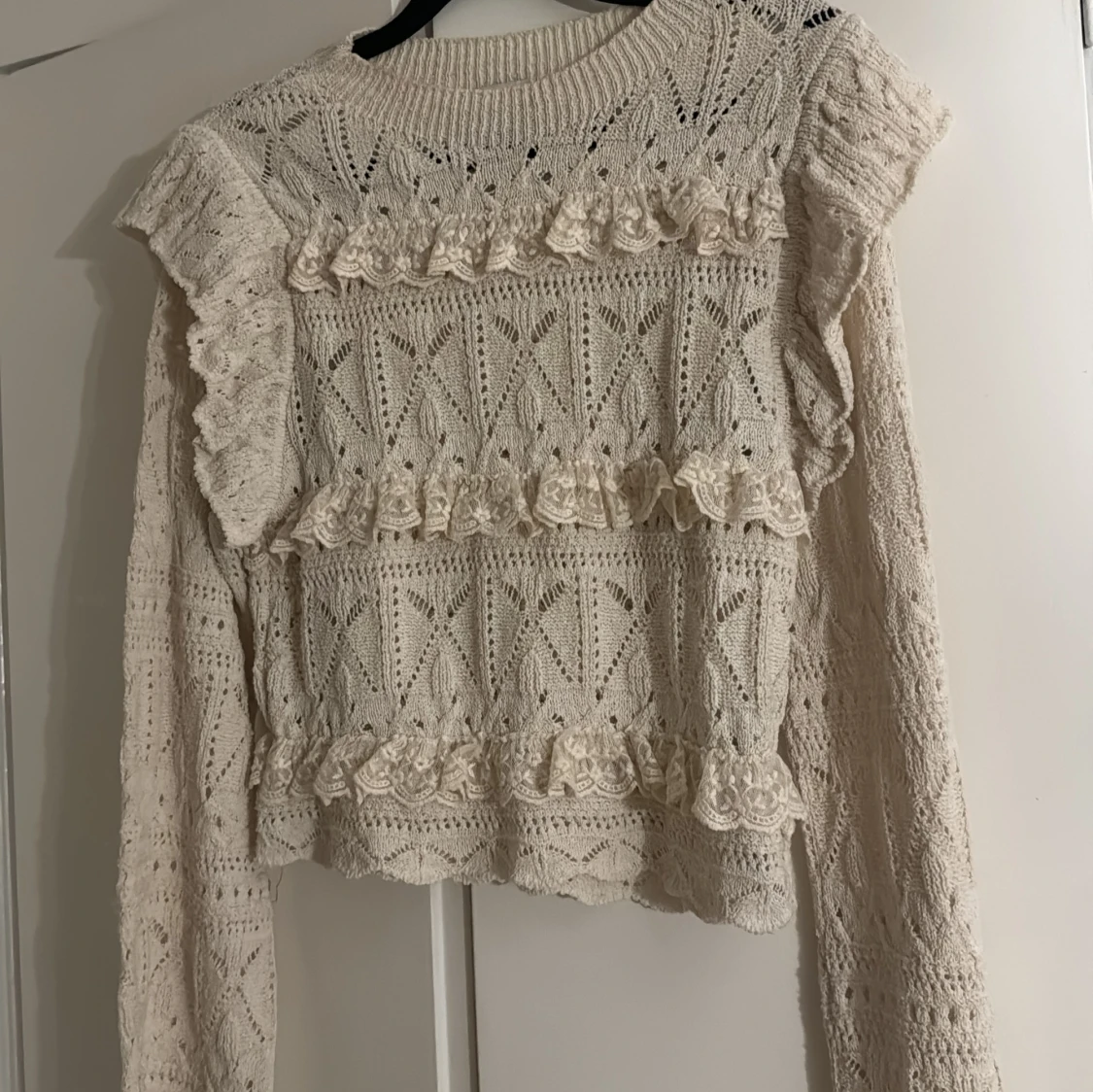 Beige stickad tröja med volanger