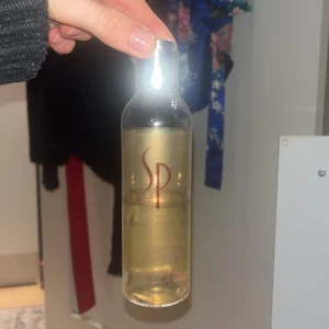Wella SP LuxeOil 200ml - Wella SP LuxeOil är ett schampo i en genomskinlig plastflaska med silverlock. Innehåller 200 ml och har en gyllene oljefärg. Perfekt för att ge håret glans och mjukhet med en lätt formula. Använt ca halva