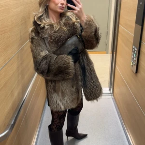 Äkta tvättbjörn pälsjacka  - Säljer en fluffig och lyxig brun pälsjacka med bred krage och lång ärm. Jackan har en naturlig färgskiftning i brunt och beige och ger en riktigt statement-look. Perfekt för dig som vill sticka ut och hålla dig varm under kyliga dagar. Även skinn detaljer under armarna vid sidorna vilket är såååå snyggt. Min absolut favorit jacka så vill helst inte sälja den, men behöver pengarna inför en resa. Finns ingen speciell storlek men passar mig bra jag är som en xs/s. Köptes ny för 6500. 