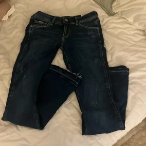Low waist flare jeans från Pepe Jeans - Snygga mörkblå jeans från Pepe Jeans med flare-ben och rå kant längst ner. Pris går att diskutera 