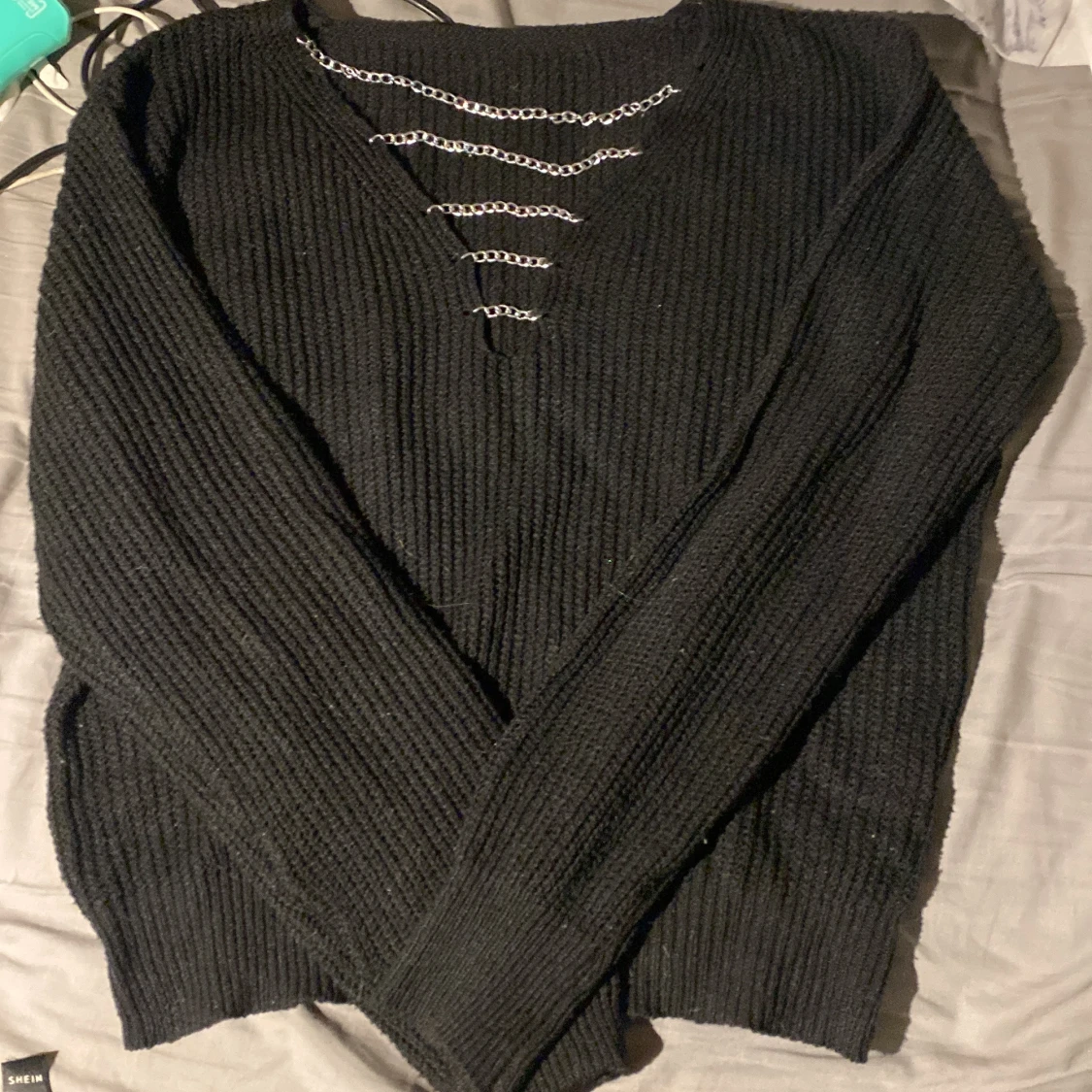 Svart stickad tröja med kedjedetalj