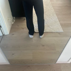 Svarta kostymbyxor Gina Tricot 34 - Säljer ett par svarta kostymbyxor från Gina Tricot i storlek 34. Byxorna har raka ben, hög midja och stängs med dragkedja och hake. Snygg passform och klassisk look, perfekta till en stilren outfit.