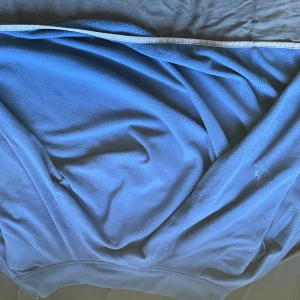 Blå fleece tröja från McKinley XS - Blå fleece tröja från McKinley i storlek XS. Tröjan har en enkel design med dragkedja på fickan och mjukt material som är perfekt för kyliga dagar. Passar dig som gillar outdoor och vill ha något bekvämt och funktionellt.