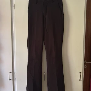 Svarta kostymbyxor med raka ben - Snygga svarta kostymbyxor med hög midja, klassisk rak passform och pressveck från bikbok. Modellen heter Vilma. Materialet känns mjukt och följsamt. Använda fåtal gånger. Nypris 499