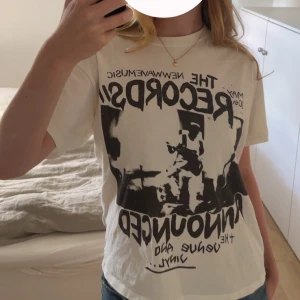 Vit-tshirt med grått tryck - Säljer en vit t-shirt med coolt grå bandtryck framtill. Trycket har texten 'THE RECORDS', 'NEW WAVEMUSIC' och en grafisk bild av ett band på scen. T-shirten har en klassisk passform och är i mjuk bomull. Baksidan är helvit utan tryck. Använd ett fåtal gånger och är i nyskick. Skriv gärna innan du köper och om du har frågor, pris kan diskuteras 💗