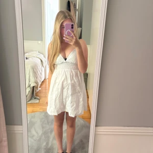 Vit klänning  - Supersöt vit klänning med smala axelband och v-ringad hals. 