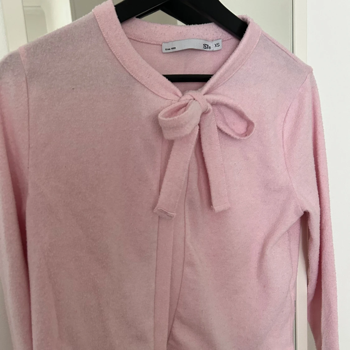 Ljusrosa kofta med rosett från 157