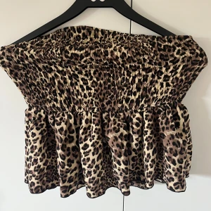 Leopardmönstrad bandeau tubtopp - Snygg bandeau tubtopp med leopardmönster och volangkant nedtill. Storlek L