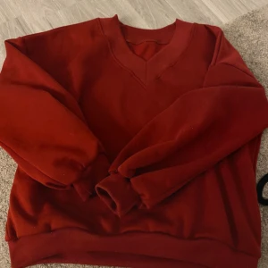 Röd sweatshirt med v-ringad hals - Säljer en enkel och snygg röd sweatshirt med v-ringad hals. 