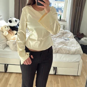 Satin blus - krämvit/ljus gul tröja som man knyter i ryggen! Saknar strlk och etikett skulle säga att den mitsvarar M