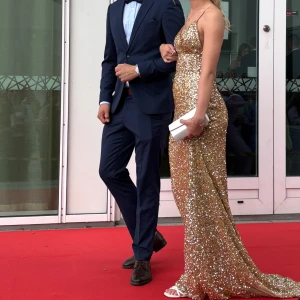 Guldig glittrig balklänning med öppen rygg - Säljer min såå fina balklänning som jag hade nu på balen. Klänningen är från Dressroom Linne i Gbg och nypris är 4995kr. Klänningen är i guld med glittriga paljetter över hela klänningen. Klänningen har smala axelband, v-ringning och en öppen rygg samt ett släp. Passformen är slim och materialet är syntet. Klänningen är sydd utifrån italienska mått vilket även gör att storleken är mindre än vad den är, då jag normalt har 34/36. Fler bilder och mått finns att få! OBS! Tryck ej på ”köp direkt” ❤️