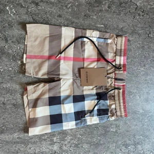 Rutig Burberry shorts med snörning - Ett par burberry shorts som är i storlek M men för mig som är 182 cm och väger 71 kg så sitter de som XS. De är pefeckat för att ha till vardags eller till poolen.